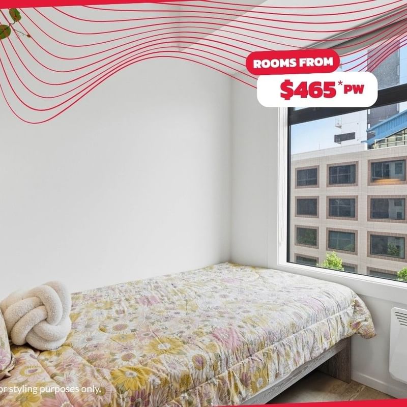 A cozy student room with a single bed, floral decor, and window at Mayoral Drive Student Accommodation.