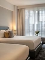 Beds with a side table and couch near the window in Loft Suite 2 King Beds at Warwick Le Crystal Montreal