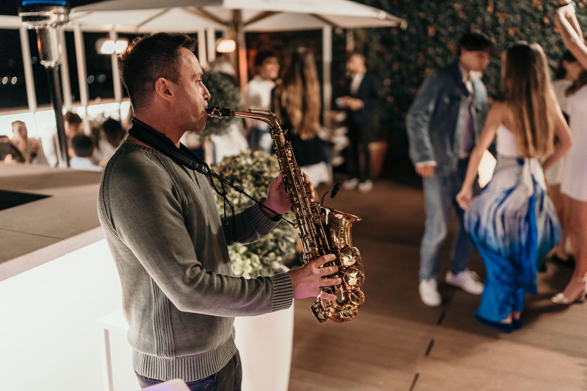A musician plays saxophone at Terrazza Cielo as guests dance and enjoy the mood under soft lights at The Independent