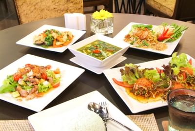 Varity of dishes served on a table at Amora Neoluxe Hotel Bangkok