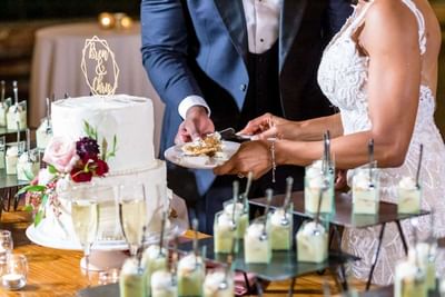 The newlywed couple at Park Hotel Hong Kong cut their decorated wedding cake, surrounded by celebratory friends and family