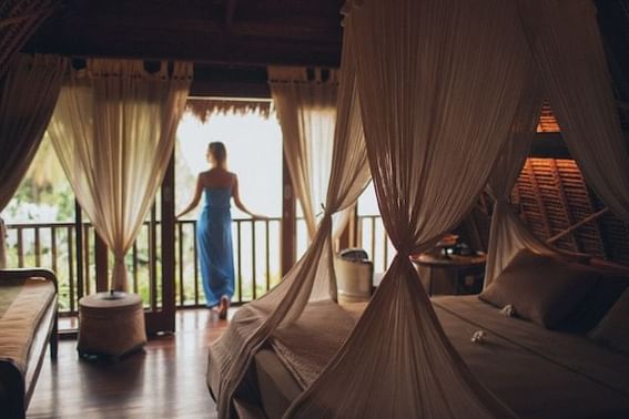 A woman standing on the balcony of a loft hotel room