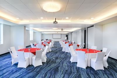 Bright meeting room with round tables, chairs & modern decor at D Sabana Hotel, San Jose Costa Rica Hotel