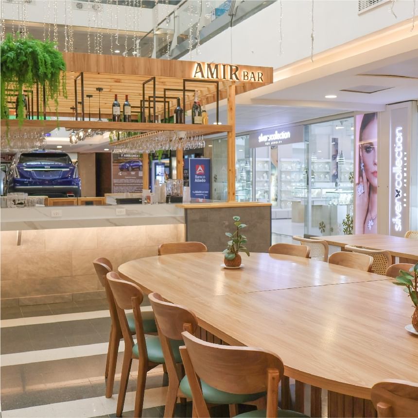 Interior de Amir Bar con mesas de madera, sillas cómodas y barra abierta moderna en Megapolis Hotel Panama