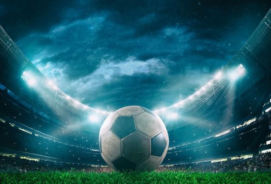 Soccer ball resting on the field in a stadium under stormy skies and bright lights near Paramount Hotel Seattle