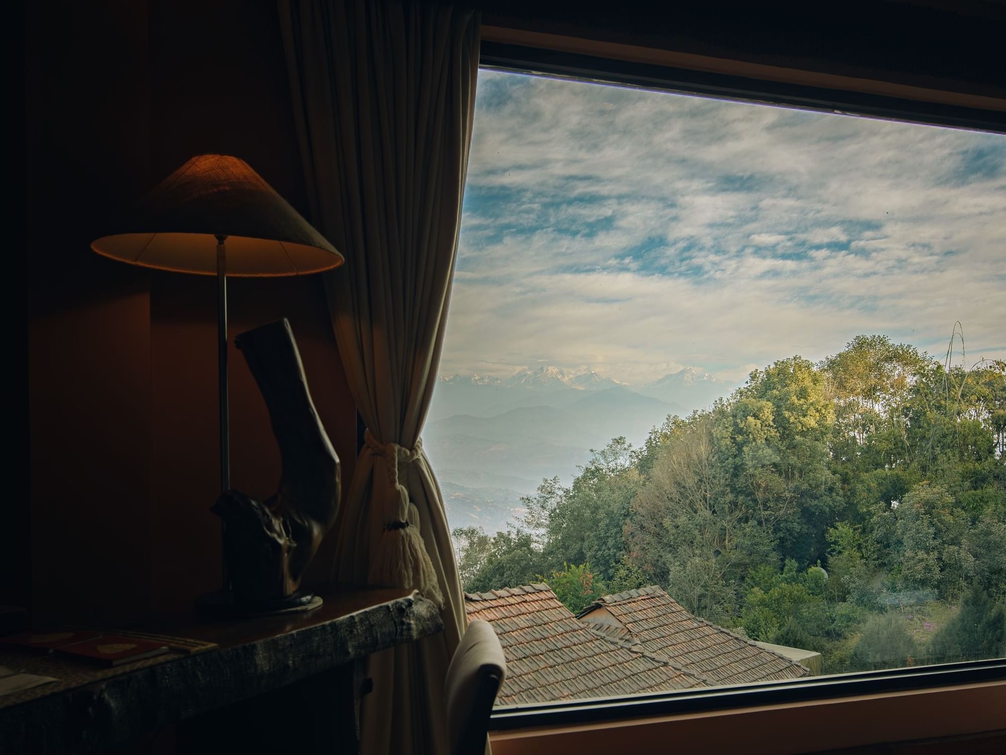 Junior Suite featuring a lamp beside a window with a lush greenery view at Dwarika's Himalayan Wellbeing