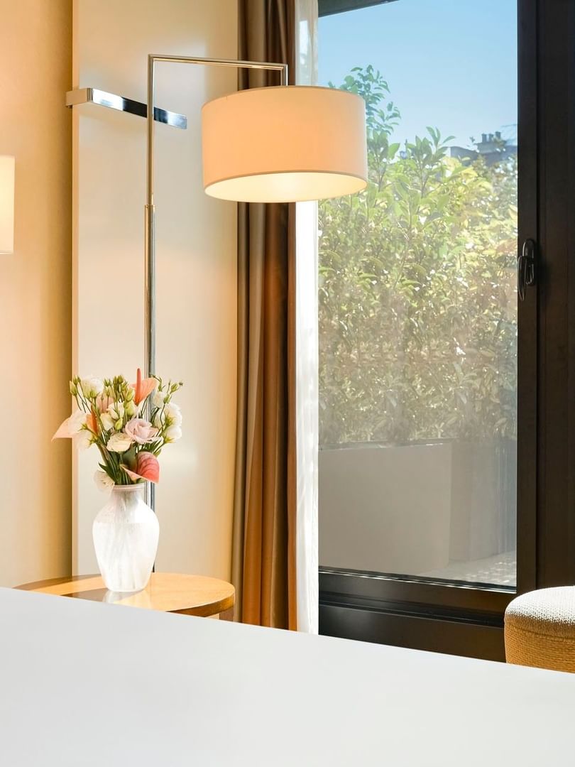 Deluxe Terrace Room with White bed by a floral vase under a large floor lamp at Warwick Geneva