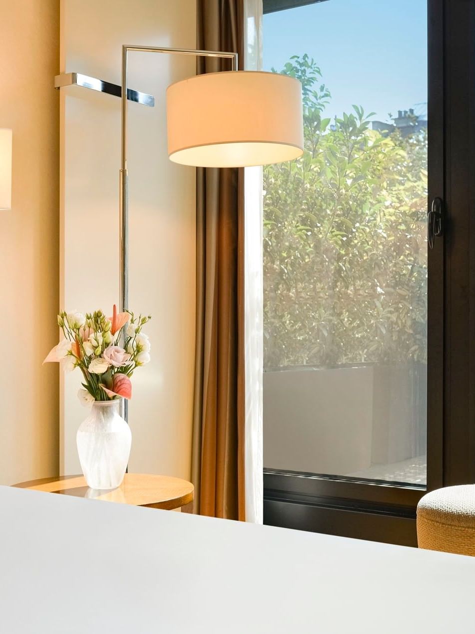 Deluxe Terrace Room with White bed by a floral vase under a large floor lamp at Warwick Geneva