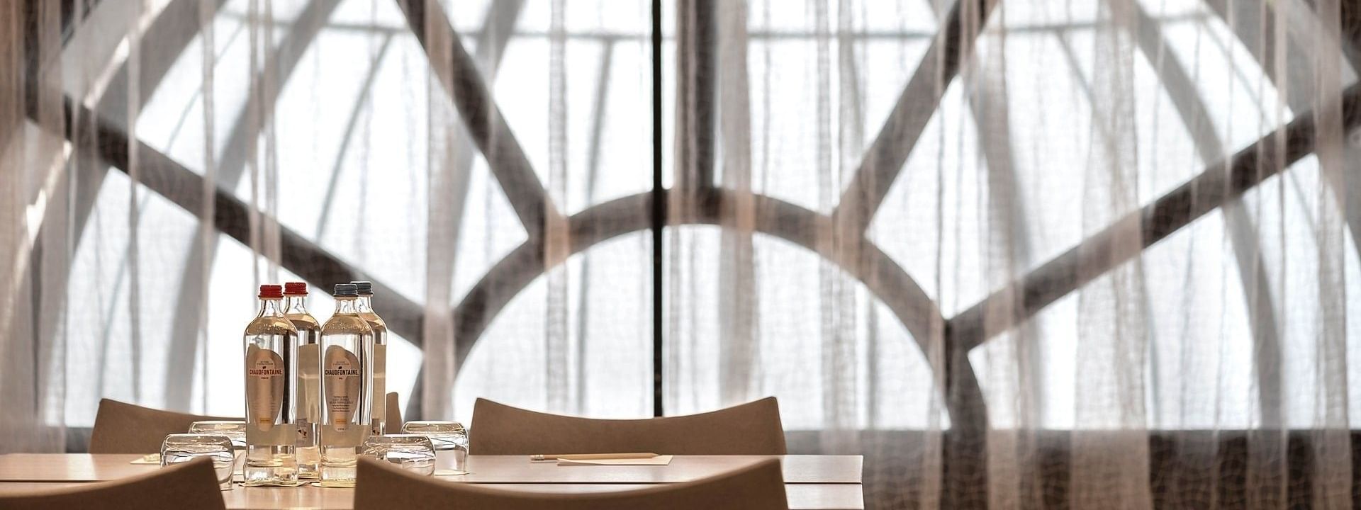 De evenementenzaal Barsey II met tafel en stoelen voor een groot raam in Hotel Barsey by Warwick in Brussel.