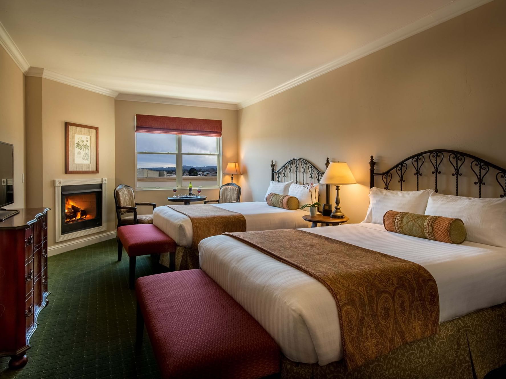 Deluxe queen room with two beds and a fireplace