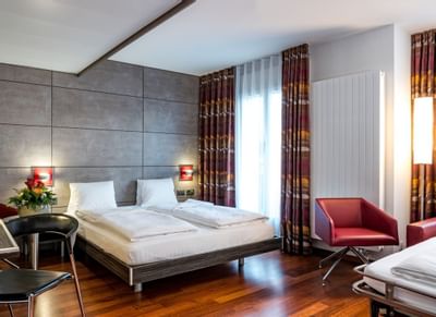Beds & armchairs in Triple Room at Hotel Sternen Oerlikon