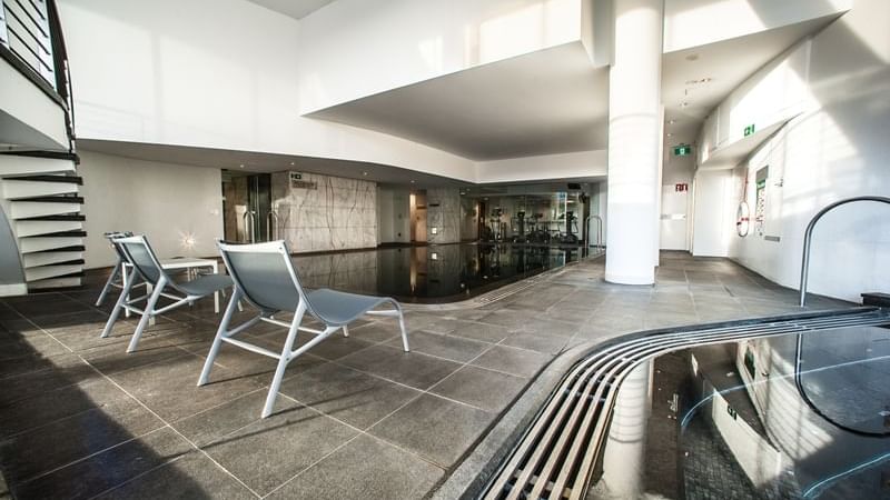 Indoor Pool area with lounges at Pullman Quay Grand Sydney