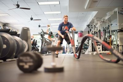 man doing rope workout in fitness center
