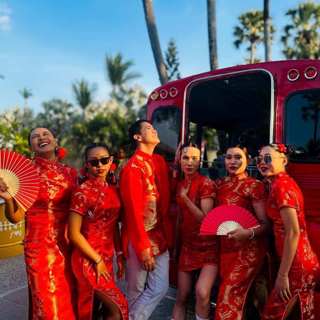 A group of people wearing Chinese costume in front of MINT Bar & Restaurant acting cool during the evening time