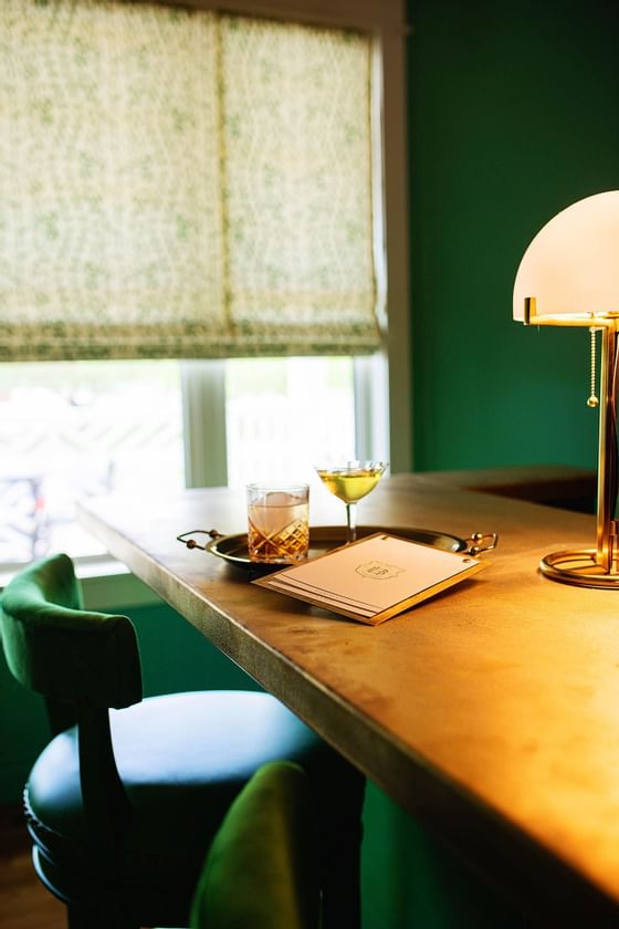 green chair at table with whiskey glass