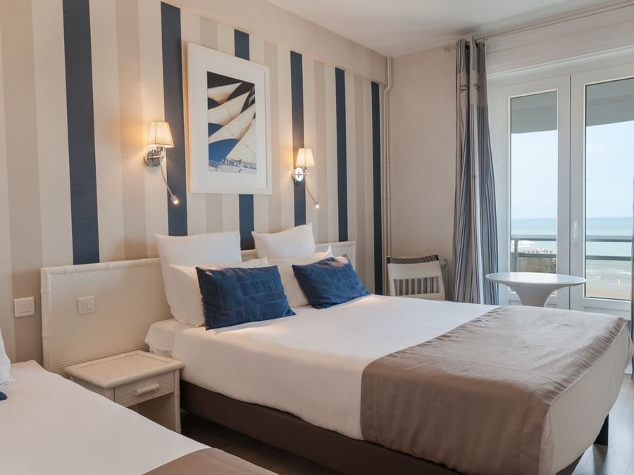 Triple Room bedroom with sea view at The Originals Hotels