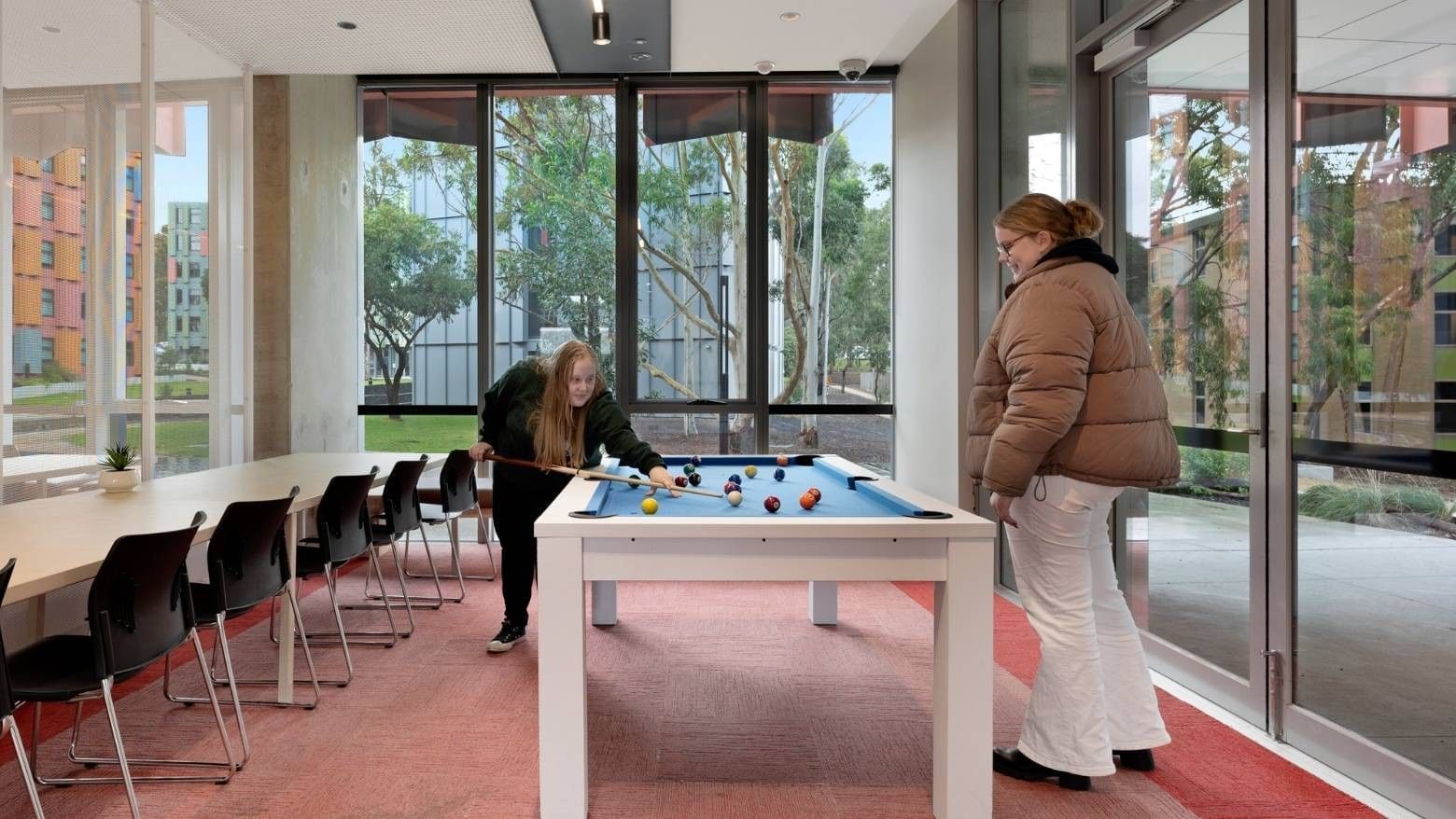 Two women playing pool in a recreational area at La Trobe University - North and South Apartments.