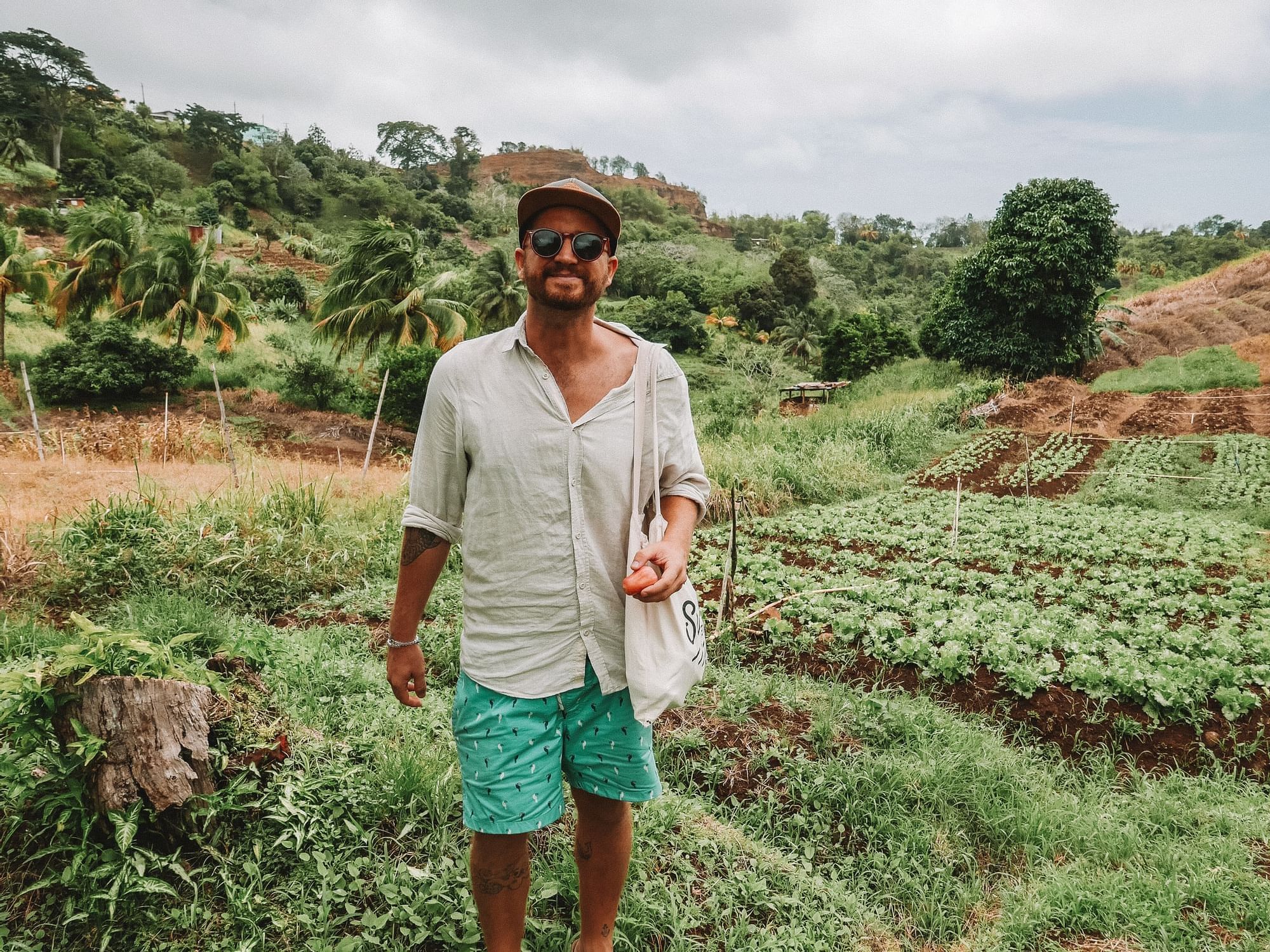 A man posing by a farm near True Blue Bay Hotel