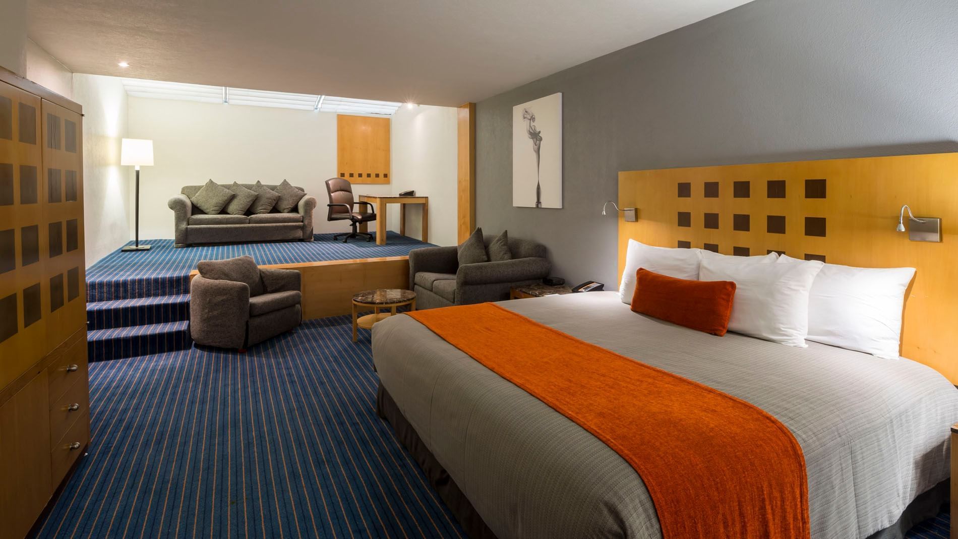 King Deluxe Superior with a separate sitting area and a large comfort bed at Real Inn Nuevo Laredo