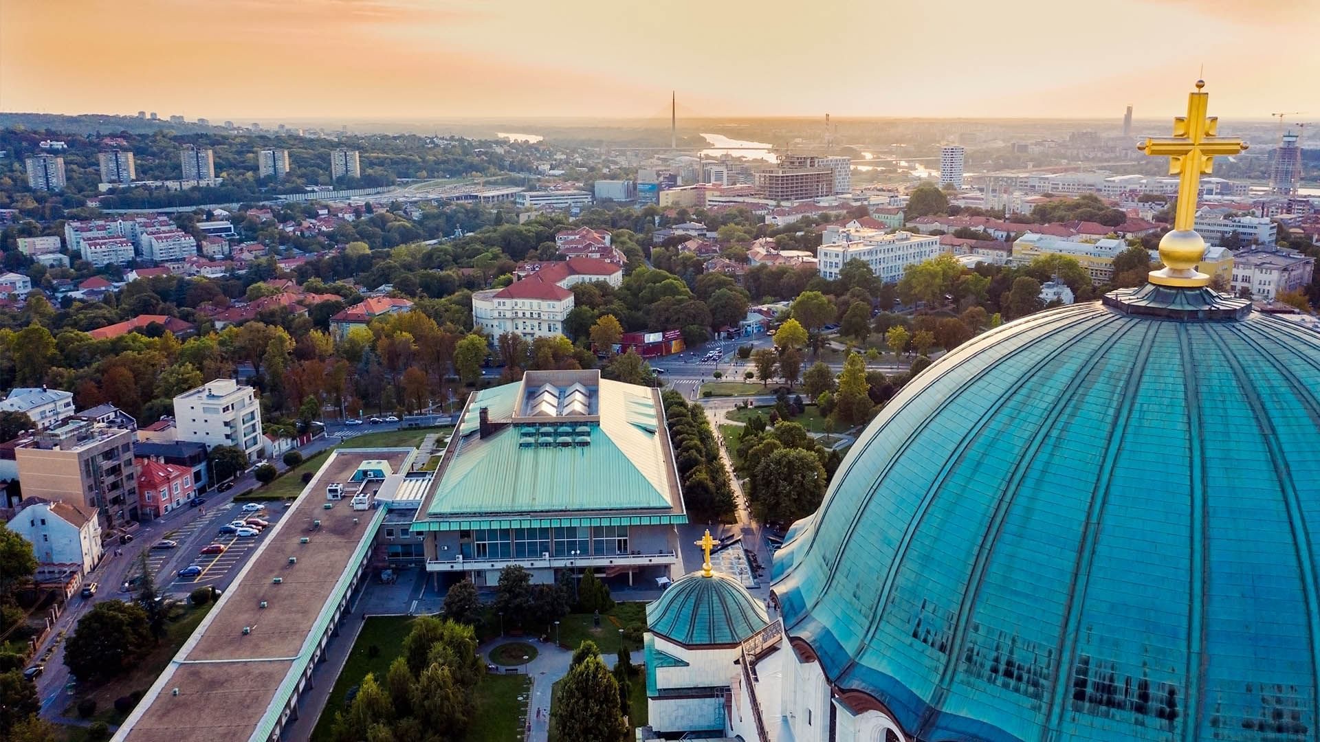 Aerial view over a cityscape with domed buildings near Falkensteiner Hotel Belgrade at sunset