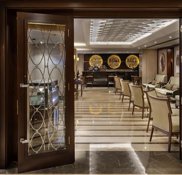 Entrance to Pascarella Restaurant Cafe Bar with glass doors and interior view of dining area with chairs in Titanic City Taksim.