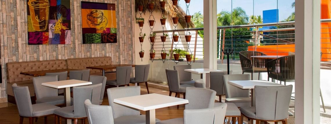 Al Fresko with a salad bar, sleek decor, and outdoor view, featuring tables and chairs for dining at Sunset Plaza Resort