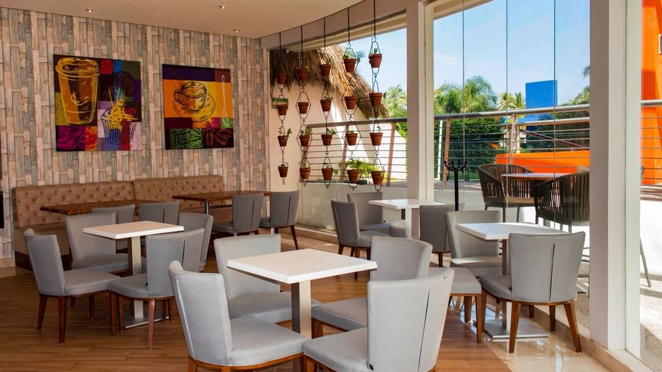 Al Fresko with a salad bar, sleek decor, and outdoor view, featuring tables and chairs for dining at Sunset Plaza Resort