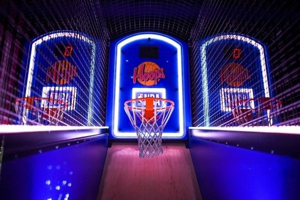 Neon lights glistening on an NBA Hoops arcade game.