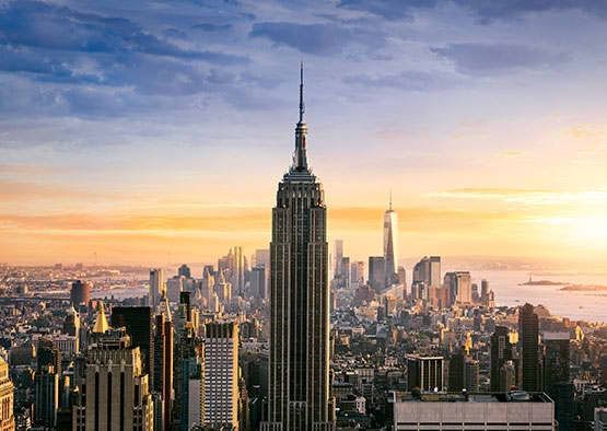 A cityscape at sunset with skyscrapers in the foreground and background