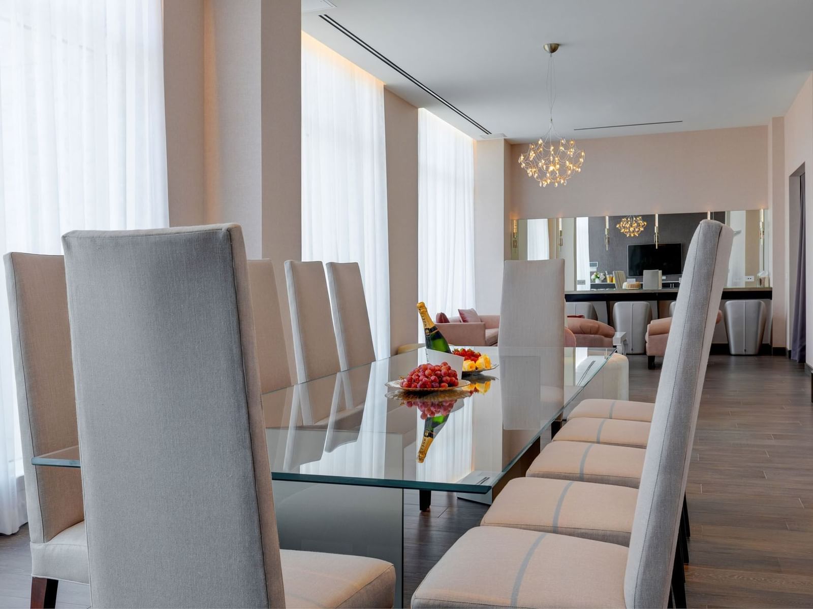 The Pearl dining room with glass table, high-back chairs, and elegant chandeliers at Hotel X Toronto