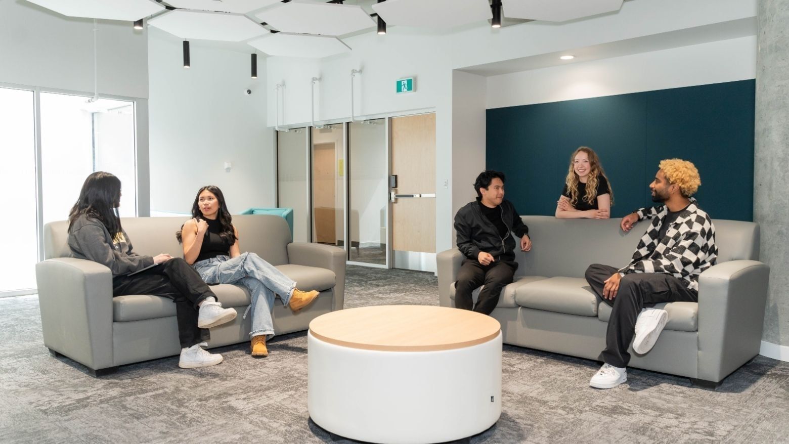 University students connect in light and modern shared lounge area.
