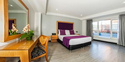 Queen size bed & dressing table in Terrace Suite at Le Manoir Bogotá Hotel