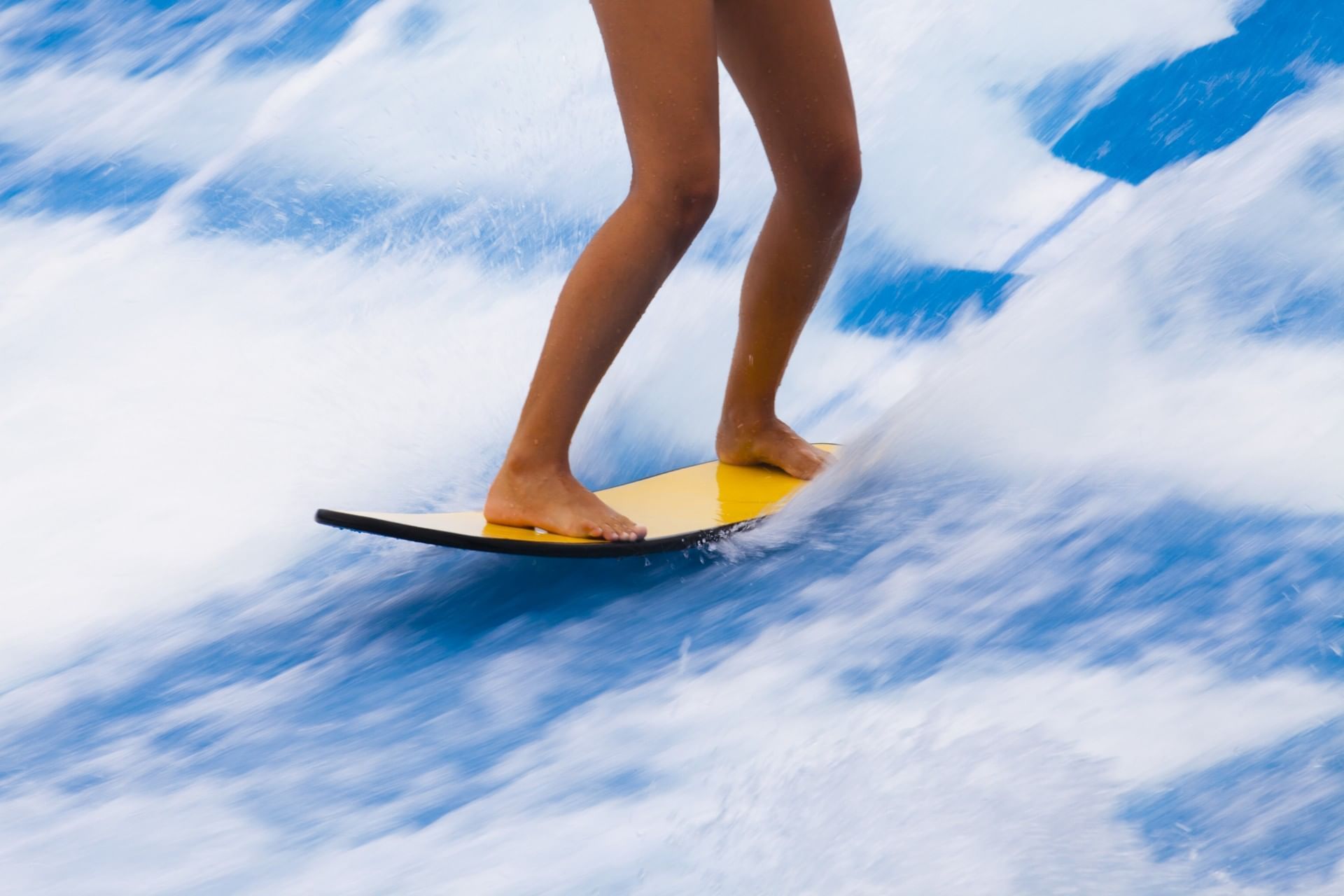 A person enjoying on a surfboard with water waves at Surfari Water Park Resort