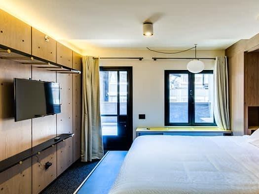  king bed and a TV in Ensemble Suite at Hotel Shocard