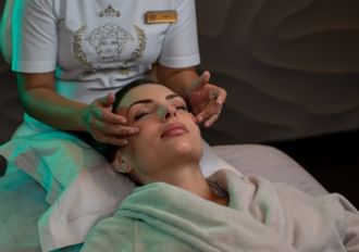 Lady receiving a head massage in the spa at Palazzo Versace