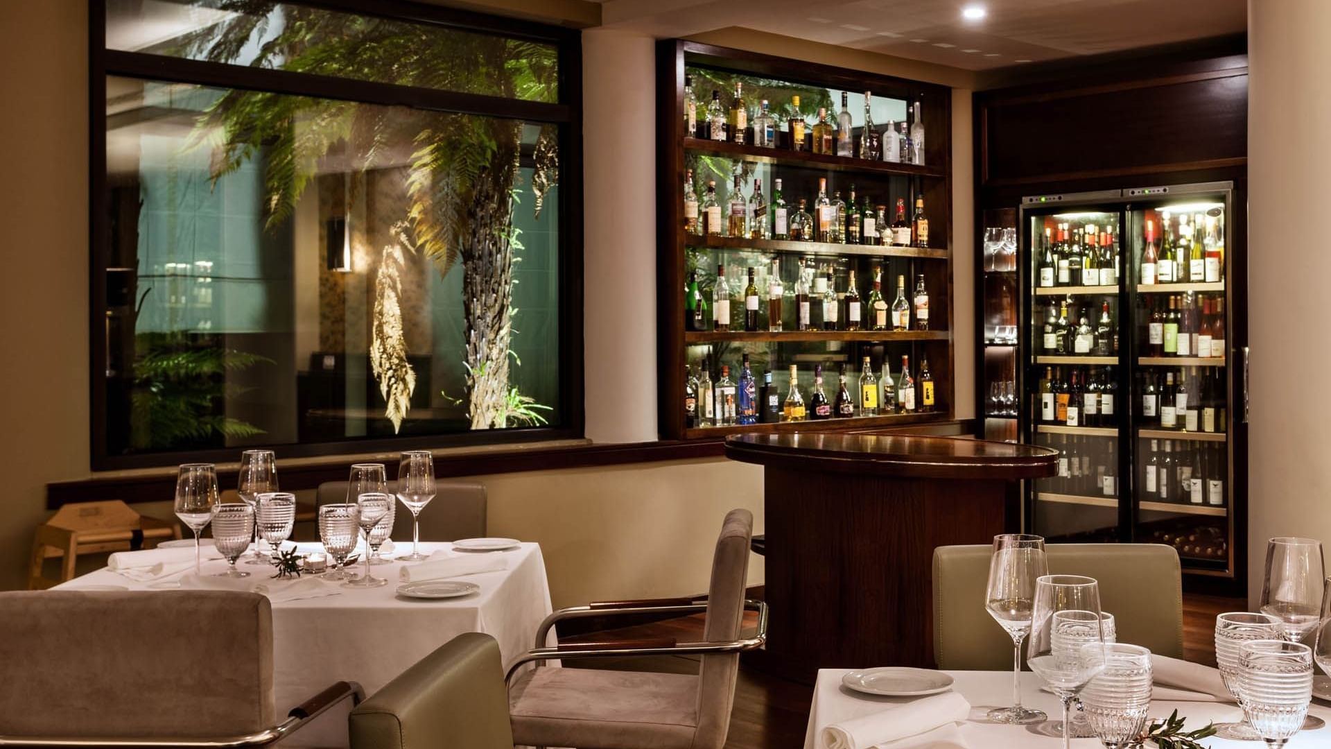 Dining tables arranged by wine racks in TN Restaurant at Terra Nostra Garden Hotel