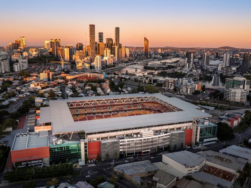 Aerial view of Suncorp Stadium and skyscrapers illuminated by sunset near Sofitel Brisbane Central