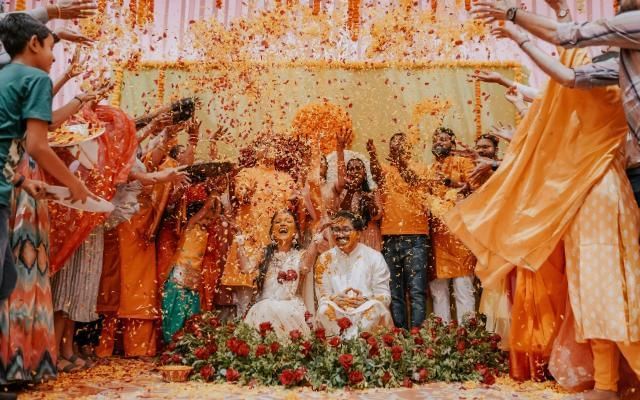 Hindu weddings featuring colourful group of guests with bride and groom in centre