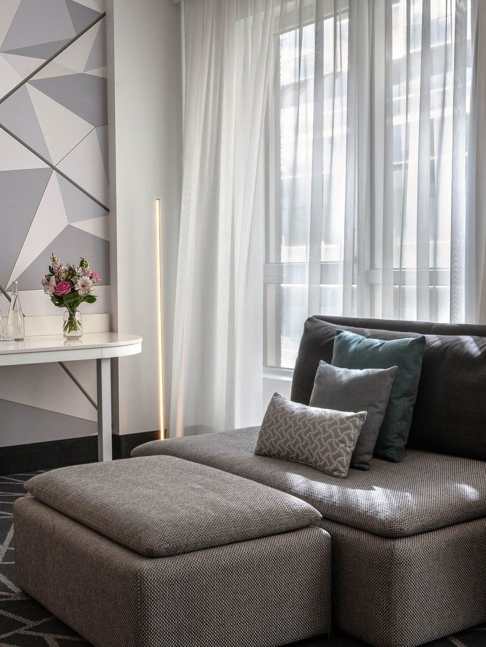 Suite Loft Premium confortable, avec un mobilier gris et des touches florales, au Warwick Le Crystal Montréal.