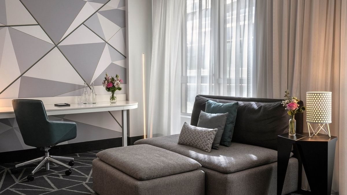 Suite Loft Premium confortable, avec un mobilier gris et des touches florales, au Warwick Le Crystal Montréal.
