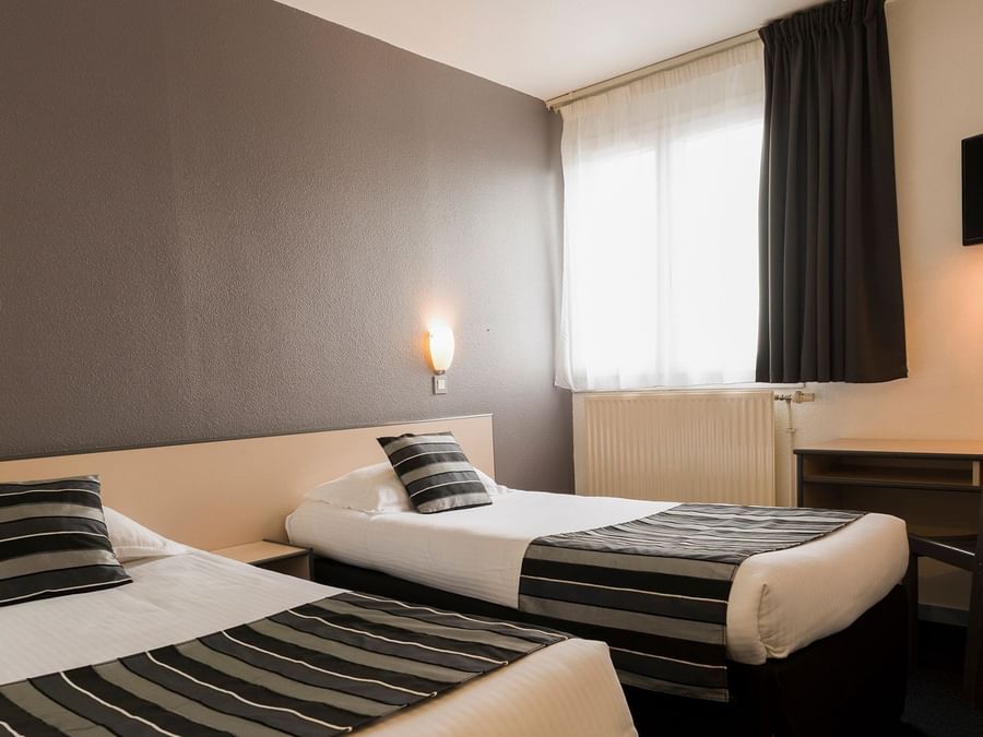 Two single beds with open windows at City hotel