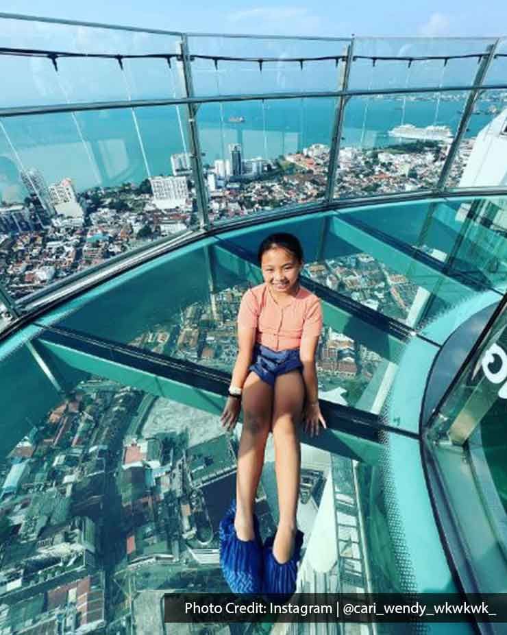 A girl was sitting on the floor at The TOP Penang Rainbow Skywalk - Lexis Suites Penang