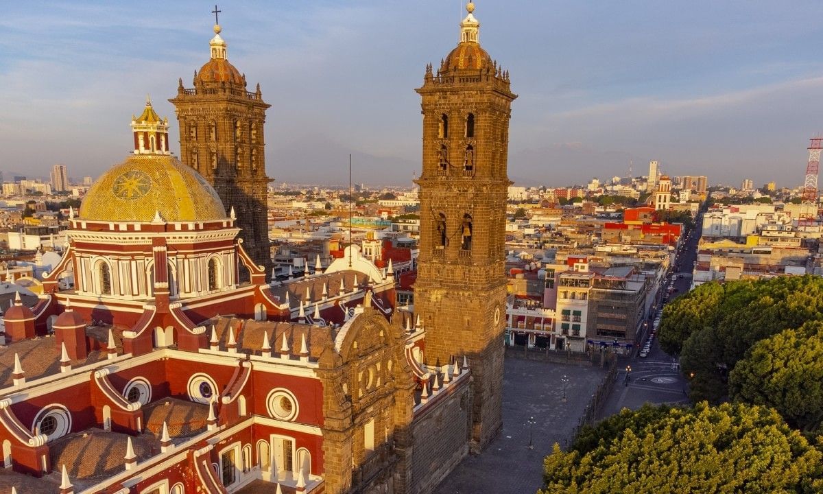 Dome church by stone towers under a sunset sky surrounding the city at Camino Real Pedregal Mexico