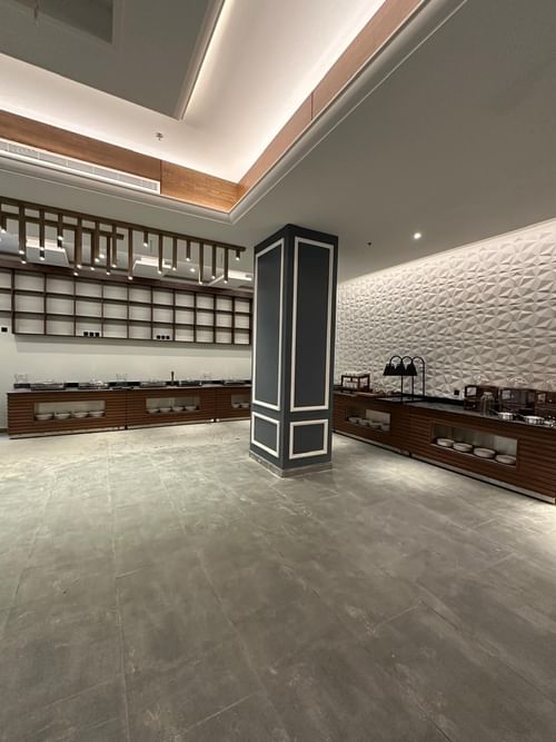 Modern buffet counter and food service area at Warwick Jeddah Hotel with textured walls