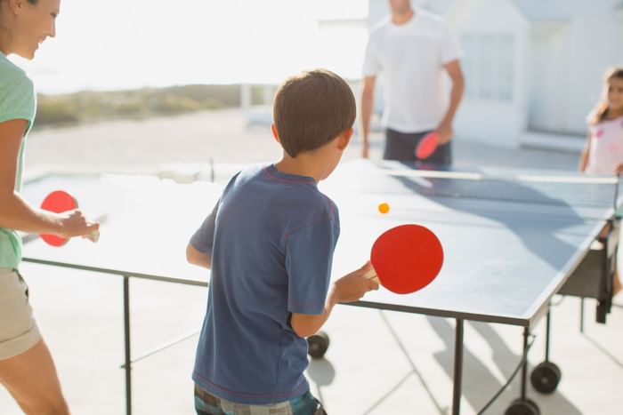 Family playing table tennis outdoors at The Diplomat Resort