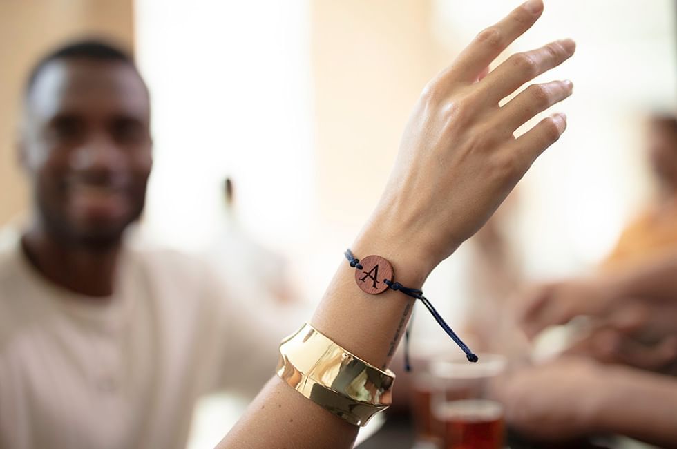 Close-up of bracelet bearing with a letter & gold cuff at Live Aqua Resorts and Residence Club