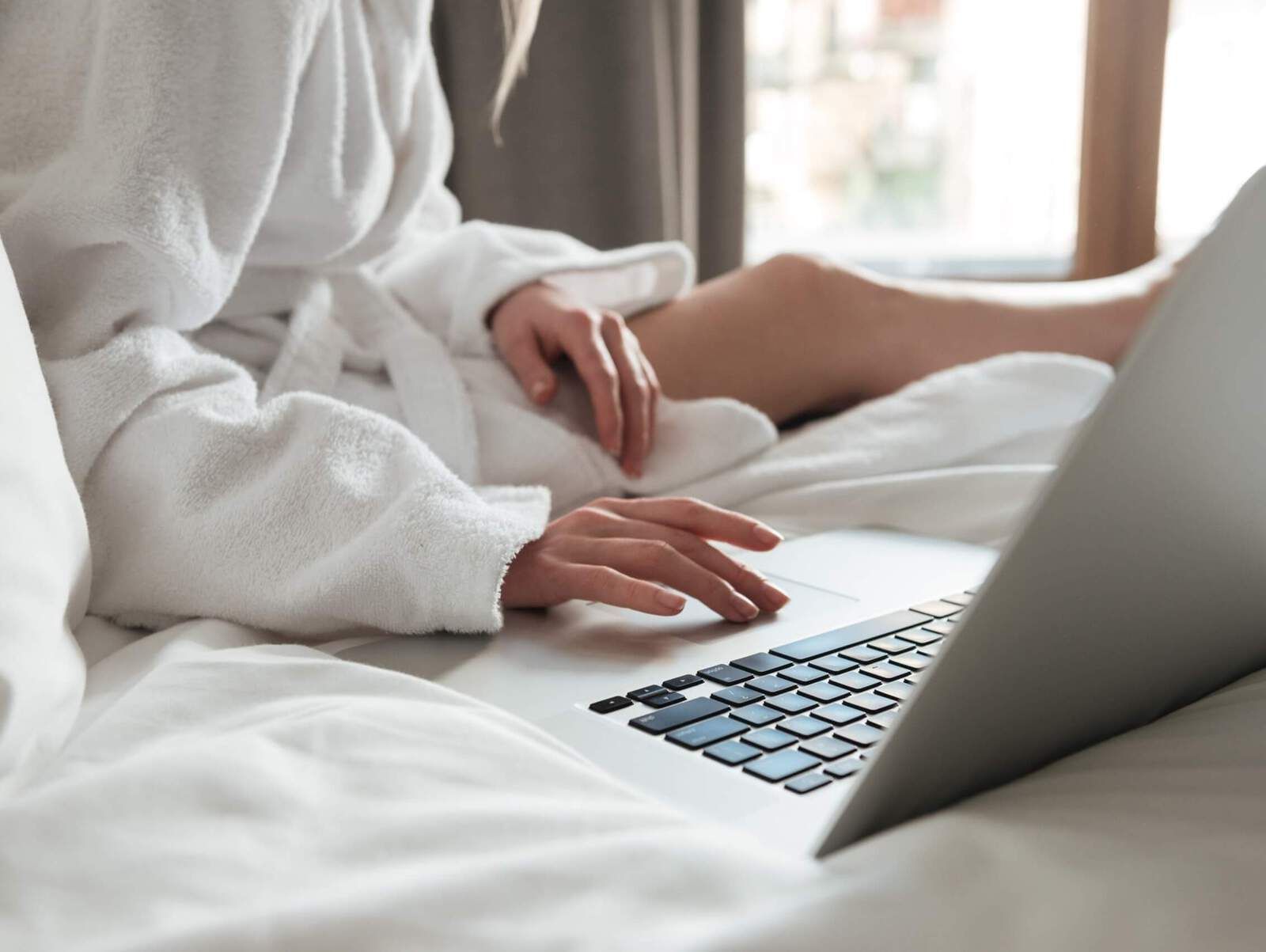 Lady is using a laptop on the bed at Park Hotel Hong Kong