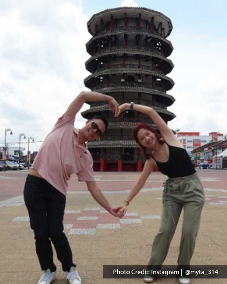 A couple were striking a pose and taking photos in front of the Teluk Intan Leaning Tower - Lexis Suites Penang