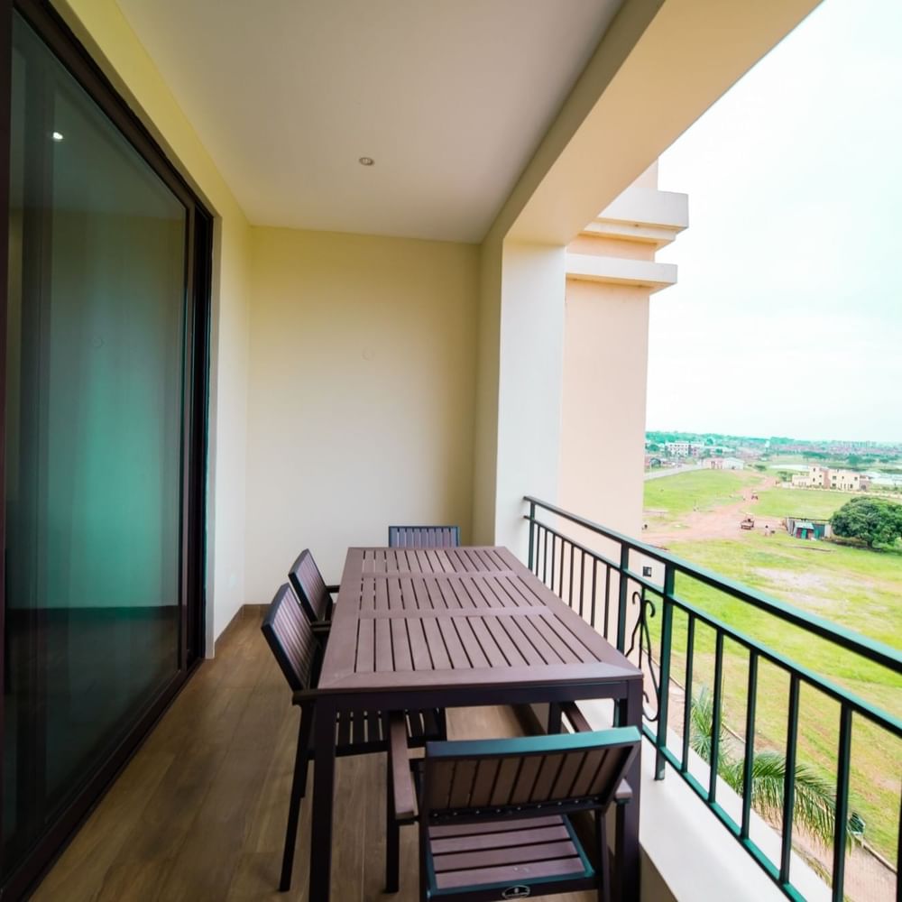 Balcony with dining set overlooking a green field at Lake Victoria Serena Golf Resort & Spa in Kampala.