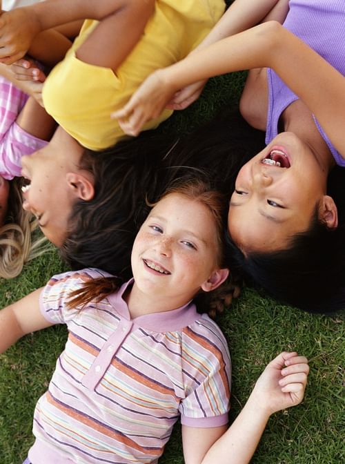 Children laughing and laying in grass